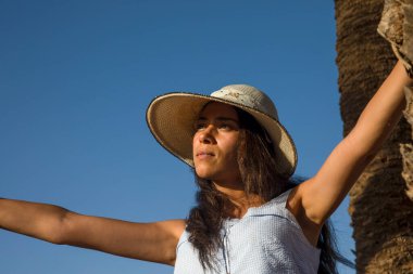 Palmiye ağaçlarının arasında Fas 'taki Marakeş' in palmiye koruluğunun tadını çıkaran seksi bir turistin yüzü. Burası turistlerin tatil ve eğlence için uğradığı bir yer..