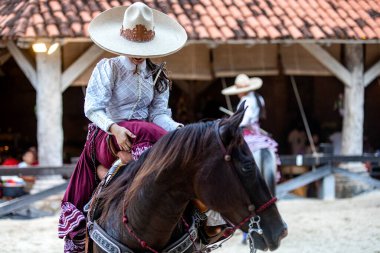 Güzel bir Meksika binicilik gösterisi, Aztek atının geleneksel şapkasıyla dörtnala giderken Meksika 'daki Xcaret Park' ta benzersiz ve inanılmaz bir gösteri..