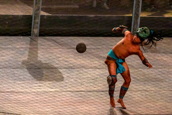Xcaret, Mexico - January 26, 2023: Mayan warrior playing the Mayan ball game at the Xcaret park show in the Mayan Riviera representing this civilization and its ancient traditions, culture and ruins.