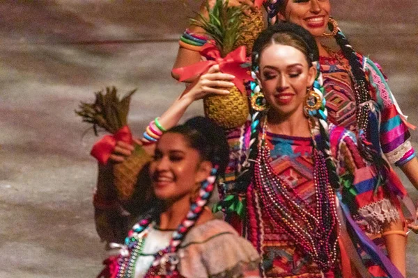 Xcaret, Mexico - January 29, 2023: Women dancing and enjoying the folkloric dance of the Oaxaca pineapple flower at Xcaret Park, in the middle of the tropical jungle of Mexico's Mayan Riviera.