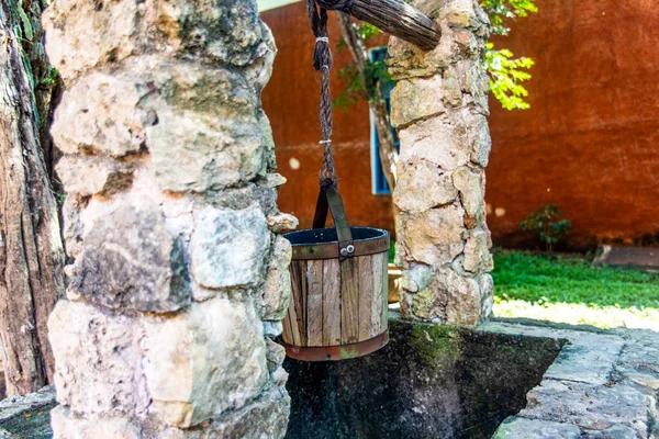 Stone water well with wooden bucket in the Mayan jungle hacienda of Valladolid in the Yucatan Peninsula (Mexico) where the cenote Samaal is located, which is fresh and potable water that rejuvenates.