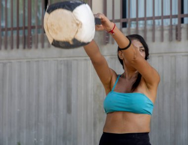 İspanyol çantasıyla çömelme hareketi yapan seksi bayan sporcular ya da çapraz formda tıp topu, bu kardiyo gerektiren bir spor. Spor konsepti.