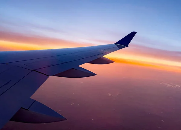 상업용 항공기의 날개가 고도로 상승중이다 아름다운 주황색 일출을 맞이하는 비행기에서 — 스톡 사진