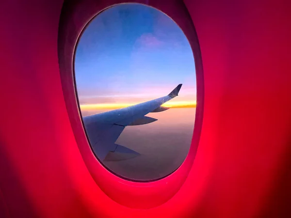飞机的内部窗口 你可以看到商业宽体翼上升到巡航高度 在美丽的橙色日出中 从一架大飞机上俯瞰空中风景 概念飞机 — 图库照片