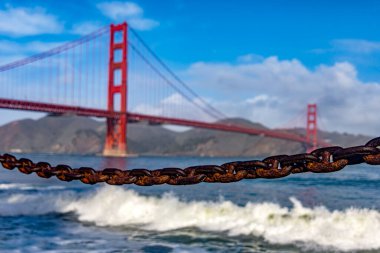 ABD 'nin Kaliforniya eyaletindeki Golden Gate Köprüsü. Okyanusu deniz kıyısından ve Kaliforniya şehrinin mavi gökyüzünün altından görüyordu. Amerikan köprü kavramı.