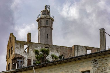 Sally Harbor ve Kaliforniya, San Francisco Körfezi 'ndeki Alcatraz Adası' ndaki ABD federal hapishanesinin gözetleme kulesiyle. Bulutlu bir gökyüzünün altında gözetleme. Hapishane kavramı.