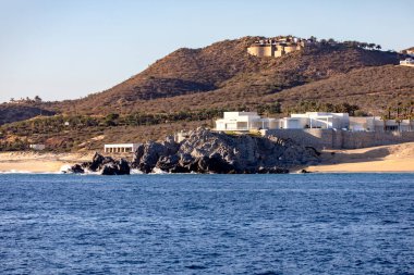 Cape Saint Luke Kemeri 'nin kıyısında Cortez Denizi' ni Baja California Sur, Meksika 'daki Pasifik Okyanusu' ndan ayıran Kaliforniya Körfezi üzerindeki güzel bir günbatımının altında konak ve evler..