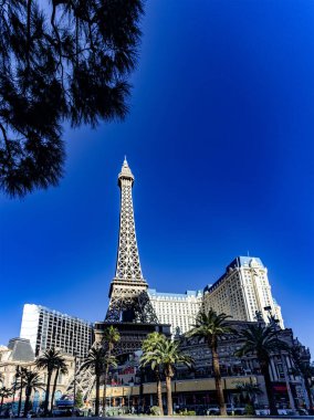 Las Vegas, ABD; 18 Ocak 2023: Paris Las Vegas Strip Oteli 'nin Eyfel Kulesi' nin dikey fotoğrafı, ahlaksızlık, kumar ve günah bulvarı mavi gökyüzü altında.