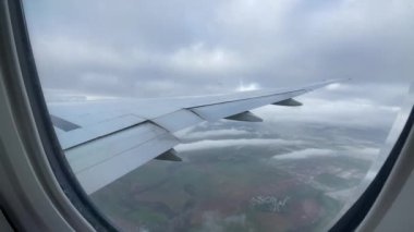 Uzun yolculuklarda turist ve yolcuları taşımak ve okyanusları aşmak, havada süzülmek için kullanılan geniş gövdeli ticari uçak kanadının iniş penceresinden bakın..