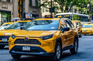 New York, ABD; 31 Mayıs 2023: Büyük Elma 'nın tipik sarı taksisi, güneşli bir günde, Manhattan' ın ortasındaki Beşinci Cadde 'den geçiyor..