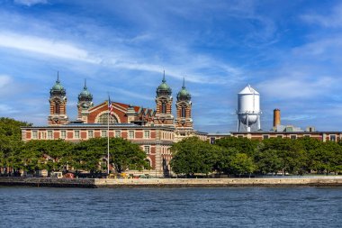 New York, ABD; 1 Haziran 2023: Ellis Adası Göçmenlik Müzesi 'nin panoramik manzarası güzel mavi gökyüzü altında, tipik New York ve Manhattan.