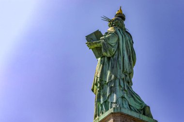 Manhattan 'da güneşli bir günde meşalesini tutan Özgürlük Anıtı' nın güzel arka fotografı, ABD 'nin New York şehrinin hanımı olarak bilinir..