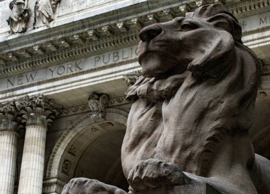 New York, ABD; 4 Haziran 2023: New York kütüphanesini koruyan mermer aslanlardan biri, bir sürü kitap içeriyor ve sinema için ayarlar yapıyor..