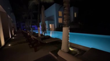 Lüks bir Grand Hotel Oteli 'nin havuzunda yürüyoruz. Geceleri aydınlık, huzur dolu bir atmosfer ve yaz tatili için ideal bir yer..
