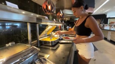 Her şeyi kapsayan otel rejiminde tipik bir Karayip lüks Grand Resort Oteli restoranından yemek seçen seksi genç turist kadın..