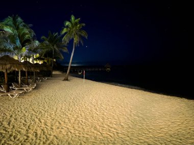 Büyük Karayip Lüks Oteli 'nin güzel kumlu kumsalı. Gecenin yıldızlı ışığı altında. Tatil tatilinin tadını çıkarmak için güzel bir ortam..