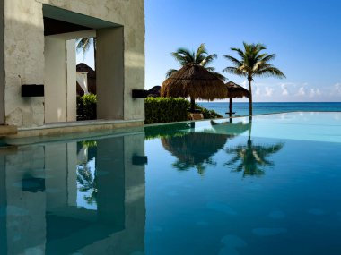 Lüks bir otel havuzunun dinlenme havuzu, arka planda kristal berrak turkuaz suyla yıkanmış, tatil ve rahatlama için ideal bir yer..