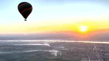 Sıcak hava balonunun sakin Nil Nehri 'ne yavaşça inişini izle. Güneş doğarken Luxor 'un nefes kesici manzarasının tadını çıkarın, antik şehrin üzerine altın bir parıltı saçın..