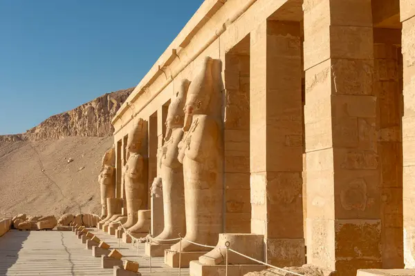 stock image The columns of the temple of Hatshepsut in Luxor are adorned with statues of the pharaoh. This architectural masterpiece is a testament to the rich history and artistic achievements of ancient Egypt.