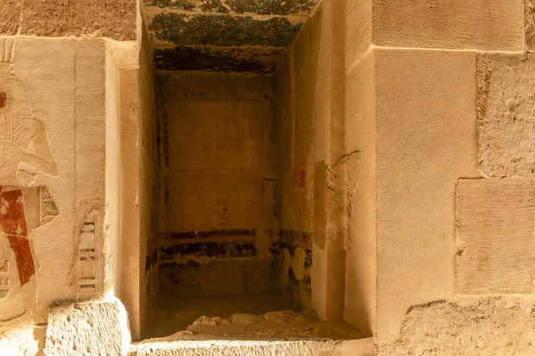 stock image A narrow, dimly lit passageway leads to a hidden chamber within the temple of Hatshepsut. Hieroglyphs and statues of Osiris offer a glimpse into the mystical world of ancient Egypt.