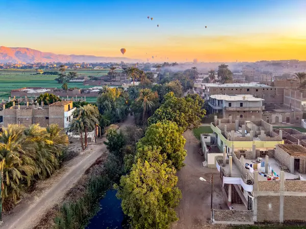 stock image Fly over the ancient wonders of Luxor and see a panorama of vibrant hot air balloons against the backdrop of the fertile banks of the Nile River, a testament to the enduring legacy of the pharaohs.