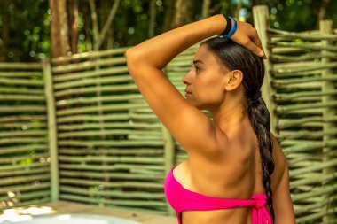 Egzotik bir inzivadaki seksi bir kadının şehvetli dinginliğini hisset. Çevresi yemyeşil bitki örtüsü ve doğa sesleri ile çevrili özel bir jakuzide dinlenen bir turist..