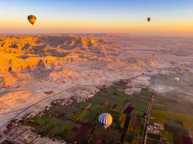 Luxor 'un sihrini, antik şehrin üzerinde sıcak hava balonuyla uçarken eşsiz bir perspektiften deneyimleyin. Bereketli Nil Vadisi ile kurak çöl arasındaki zıtlık.