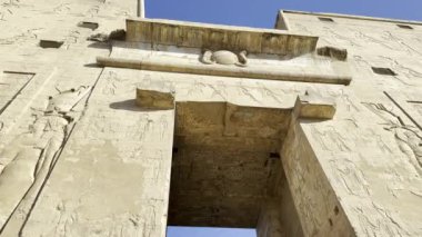 Edfu, Mısır; 17 Ocak 2024: Edfu 'daki Horus Tapınağı' nın kapılarından geç. Bu eski Mısır portalını süsleyen ve hissetiren karmaşık oymalar ve hiyerogliflere hayran kaldım..