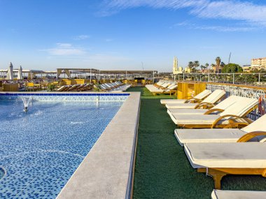 Aswan, Mısır; 18 Ocak 2024: Nil Nehri 'ndeki çatı havuzunda rahatlayın ve Firavun Nehri' nin nefes kesici manzarasının tadını çıkarın. Bu rahatlatıcı Nil deneyimi sunar.