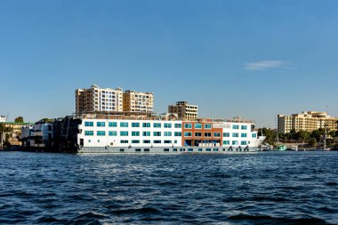 Aswan, Mısır; 18 Ocak 2024: Aswan, Mısır limanına yanaşan bir Nil Nehri yolcu gemisinin görüntüsü. Bu fotoğraf Aswan ve Nil Nehri 'nin hareketli limanını gösteriyor..