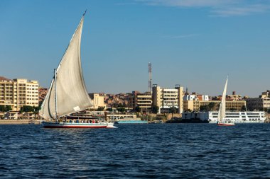 Aswan, Mısır; 18 Ocak 2024: Aswan 'da bir nehir kontrastında Nil' deki feluccas ve nehir kruvazörlerine bakın. Bu sahne, Aswan 'daki Nil' deki modern nehir kruvazörlerinin yanında geleneksel ahbapları gösteriyor..