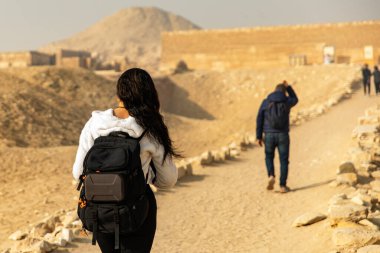Sırt çantasıyla Mısır 'ın kalıntıları arasında gizemli mezar ve piramitleri araştıran maceraperest bir turisti takip edin. Bu tarihi toprakların eski harikalarını keşfedin..