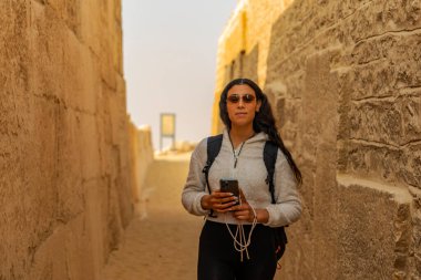 Mısır 'ın batısındaki Memphis Mezarlığı' nda, Saqqara 'da eğlenen bir turist kadın görüyorsunuz. Bu yerin tarihi harikalarını ve tarihsel önemini araştırın..