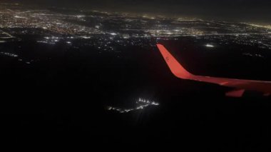 Luxor, Mısır; 15 Ocak 2024: Lüxor Uluslararası Havalimanı, Mısır 'da ticari bir uçağın aydınlatılmış iniş deneyimini yaşayın. Mısır 'da gece gökyüzüne karşı büyüleyici bir manzara.