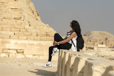 Kahire, Mısır; 20 Ocak 2024: Bir turistin Mısır 'ın Saqqara kentindeki Zoser' in Adımlı Piramidine bakışına tanık olun. Bu önemli Memphis mezarlığının tarihsel bağlamını araştırın..