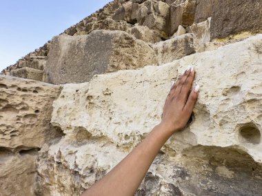 Kahire, Mısır; 20 Ocak 2024: Modern dünyanın harikalarından biri olan Mısır 'ın Giza kentindeki Keops Piramidine bir turist olarak dokunun. Antik taşları ve Firavun 'un mirasını tecrübe et..