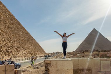 Kahire, Mısır; 20 Ocak 2024: Mısır 'daki ünlü Giza Piramitleri' nin ortasında Mycerinus, Kefren ve Keops 'un ruhlarıyla bağlantı kuran güzel bir kadına tanıklık edin..