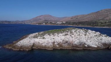 Video, temiz bir gökyüzünün altında derin mavi suyla çevrili küçük bir kayalık adanın yer aldığı bir kıyı manzarası sergiliyor. Adada görünen yeşillik yamaçları olan beyaz kayalıklar var ve çok sayıda martı yaşıyor.