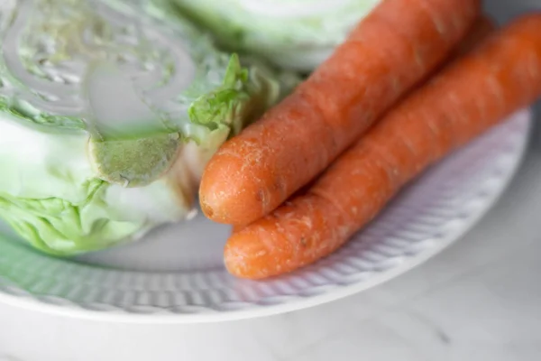 White cabbage with carrots on a white plate. Concept for weight loss. High quality photo