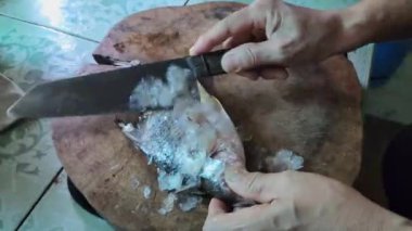 Balık pullarını doğrama tahtasında balık pulu kullanarak kaldırmak