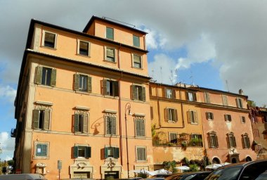 Italy, Rome, 2 Piazza di Santa Maria in Trastevere, ancient yellow mansion with shutters