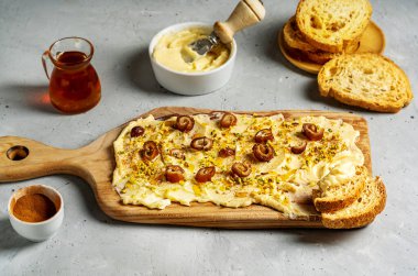 Yumuşak tereyağı, bal, tarçın, hurma ve çimento grisi arka planda crostini ile yapılan tatlı tereyağı. Üst Manzara. Trend gıda konsepti.