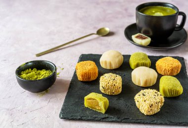 Çeşitli dokularda sofistike bir mochi ve bir kase kibrit tozu geleneksel bir Japon çay saati deneyimi için hazır..