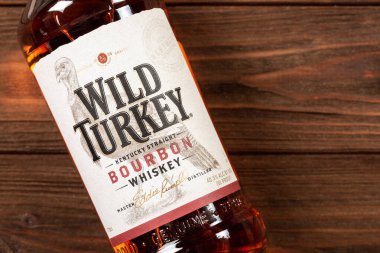 Ternopil, Ukrayna - 27 Nisan 2024: Ahşap zemin üzerinde bir şişe Wild Turkey Burbon Whiskey ve metin için boş alan