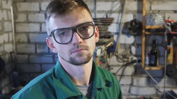Porträtt Trött Ung Reparatör Skyddande Glasögon Tittar Kameran Sitt Garage — Stockvideo