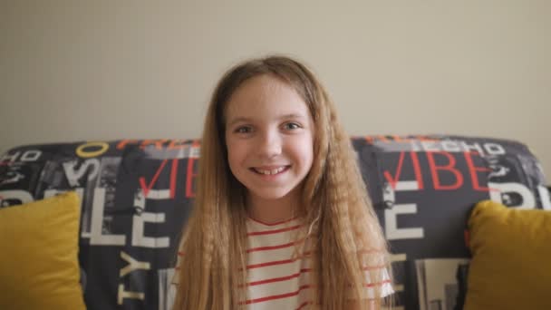 Kameraya Bakıp Içeride Gülen Mutlu Sarışın Kızın Portresi Odadaki Kanepede — Stok video
