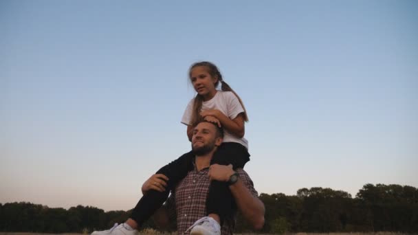 Young Father Walks Cute Small Daughter Sitting His Shoulders Meadow — Stockvideo