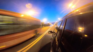 Gece şehir otobanında siyah bir cip sürüyormuş. Akşamları otomobille şehir sokaklarında dolaşmak. Araç otoban boyunca hızla ilerliyor. Arka planda manzaralı şehir trafiği. Yolculuk konsepti. POV.