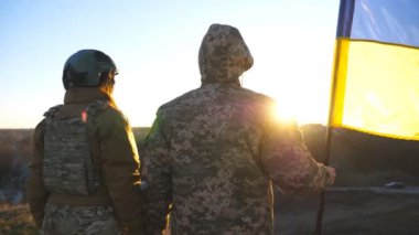 Ukrayna bayrağı sallayan Ukrayna ordusunun askerleri. Askerler, Rus saldırısına karşı zafer kazanmak için bayrağı kaldırdı. İstila direnişi ve savaşın sonu kavramı. Yavaş çekim.