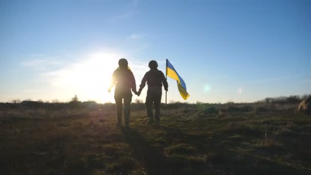 乌克兰军队的士兵跑到山顶升起乌克兰国旗 身穿军服的人拿着飘扬的旗帜作为战胜俄国侵略的胜利的象征 结束战争的概念 — 图库视频影像